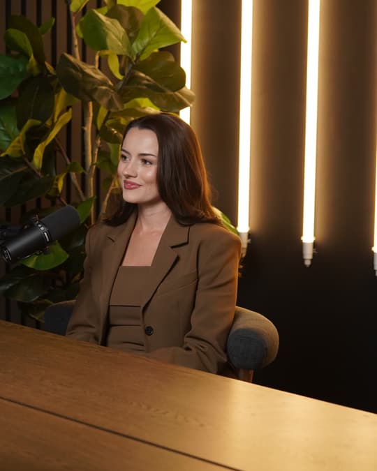 A guest in an armchair talking with his hands, filmed in the studio.